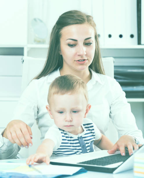 istock Girl with kid is working behind laptop 936153056