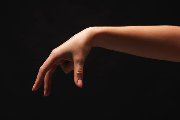 istock Female hand picking up something, cutout on black 936156870