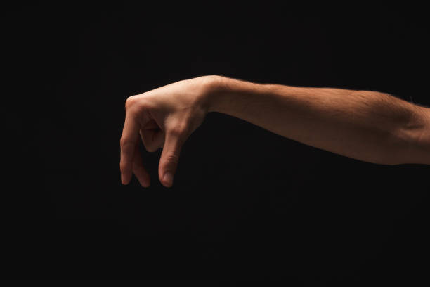 istock Male hand picking up something, cutout on black 936159696