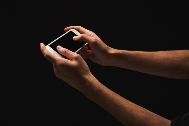 istock Male hand holding mobile smartphone with blank screen 936159888