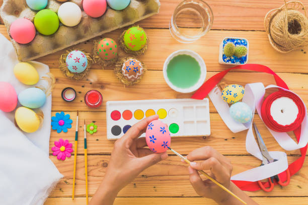 istock Happy easter! A woman hand painting Easter eggs. Happy family preparing for Easter. 936160134