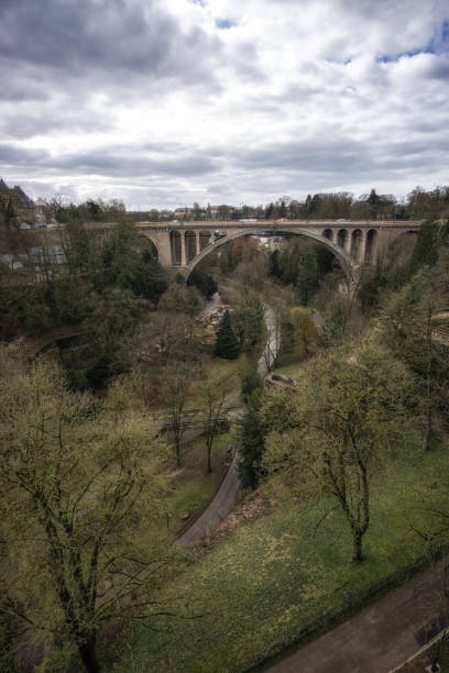 Adolphe bridge and petrusse valley Adolphe bridge over petrusse valley with view of bourbon plateau and the bank museum petrusse stock pictures, royalty-free photos & images