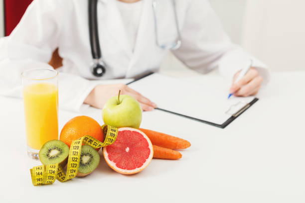 istock Nutritionist desk with fruit and measuring tape 936172804