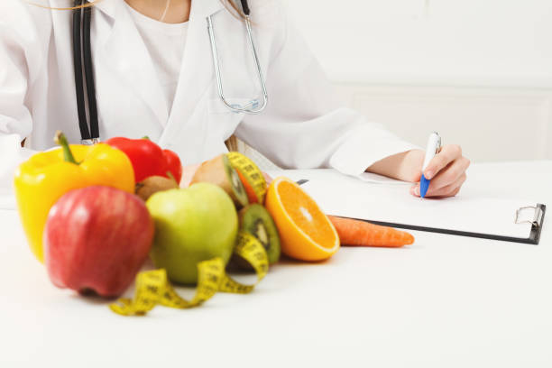 istock Nutritionist desk with fruit and measuring tape 936172962