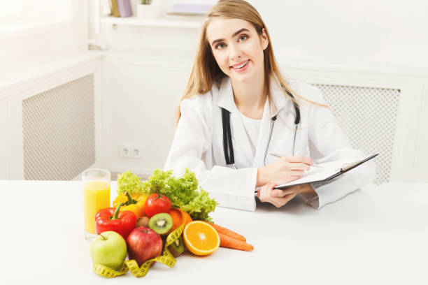 istock Nutritionist desk with fruit and measuring tape 936175612