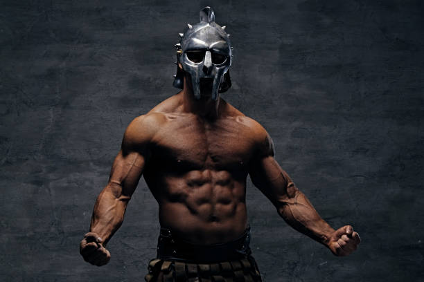 Muscular man in a gladiator silver helmet. stock photo