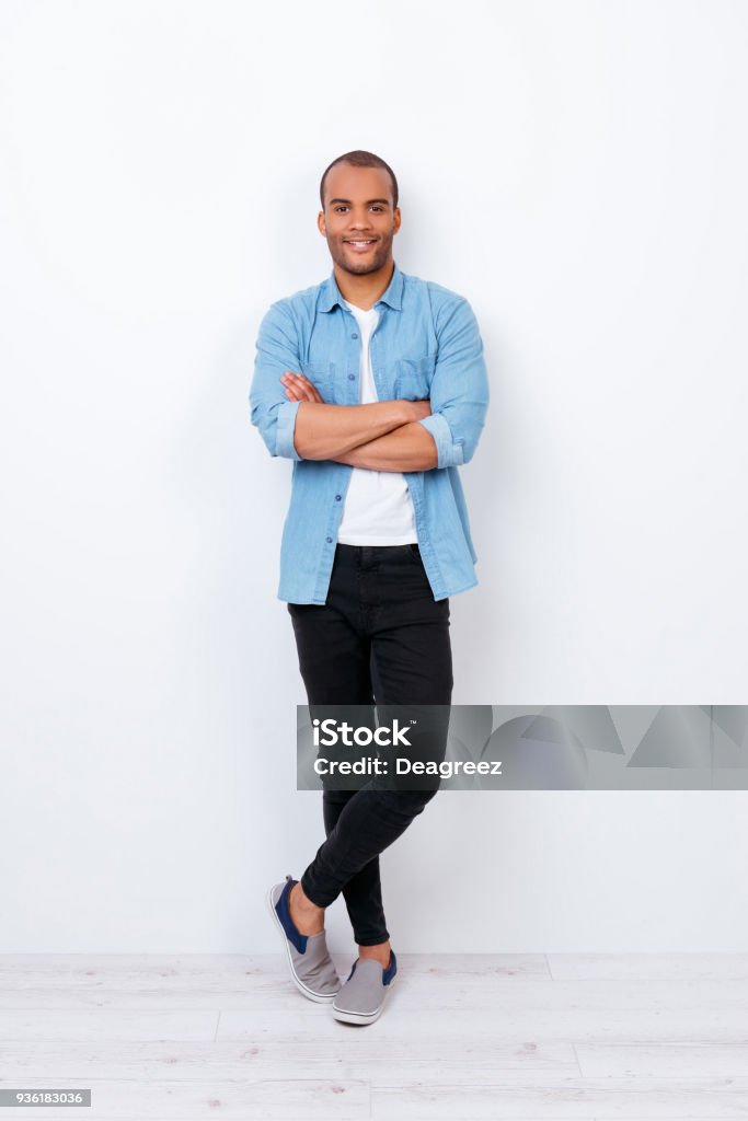 Sonriente joven guapo americano estudiante exitoso traje de mezclilla moda sobre fondo blanco puro con las manos cruzadas. Tan seguro, atractivo y elegante - Foto de stock de Hombres libre de derechos