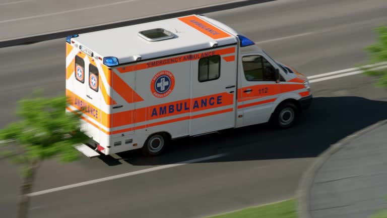 Ambulance driving on the road in the city in sunshine