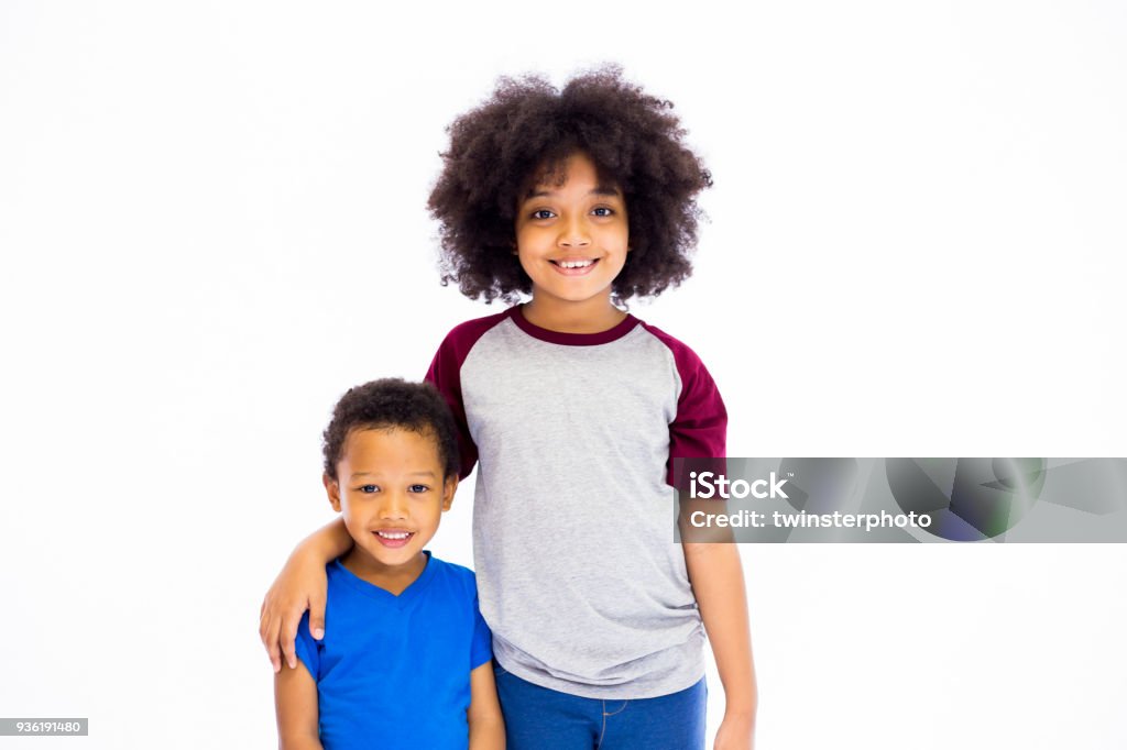 Smiling young African American sister and brother isolated over white background Brother Stock Photo