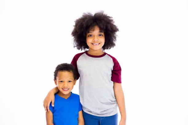 Photo of Smiling young African American sister and brother isolated over white background