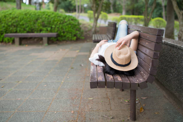 Young man resting on a grass. Face covered with hat
