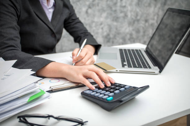 istock Business women using calculator at working with financial reports 936205774