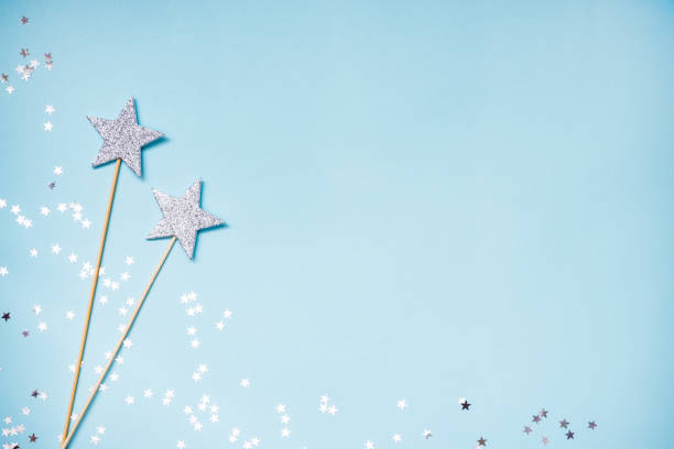 istock Two silver party magic wands and scattered sequins on a blue background. Copy space. 936206548