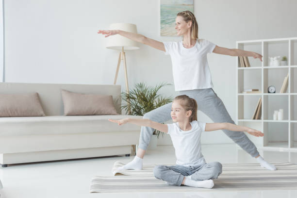 istock mother and daughter practicing yoga together 936211602