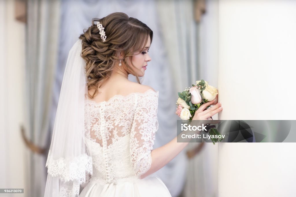 portrait of the bride on the window background portrait of the bride against the window. Vertical shot. The middle plan. Bride Stock Photo