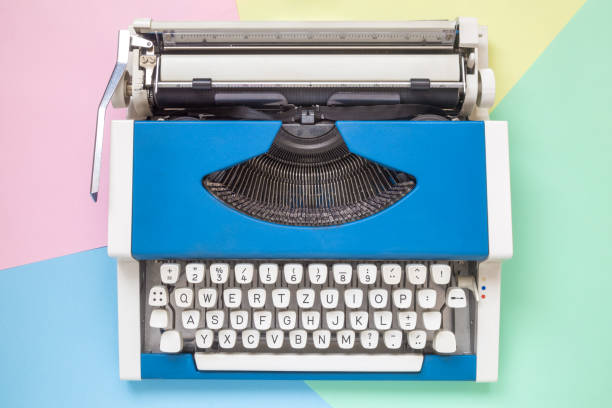 istock High angle view of retro typewriter against colorful background. 936213370