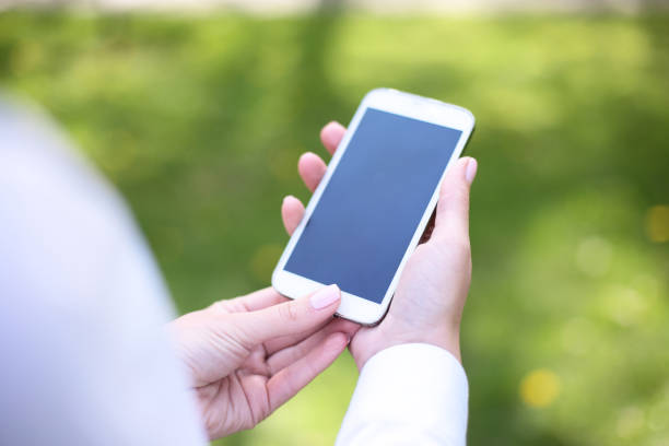 istock Woman using mobile smart phone in the park 936221862