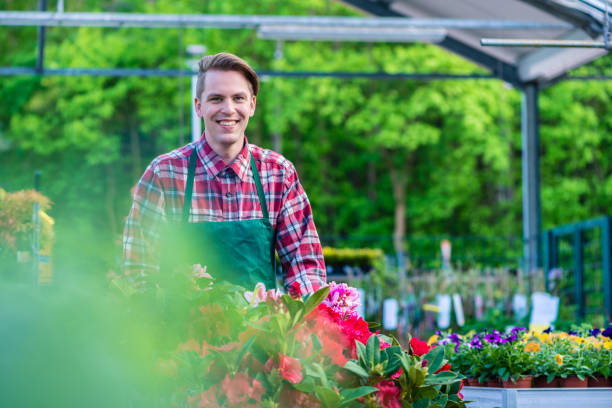 istock Handsome young man smiling happy while working as florist in a modern flower shop 936222488