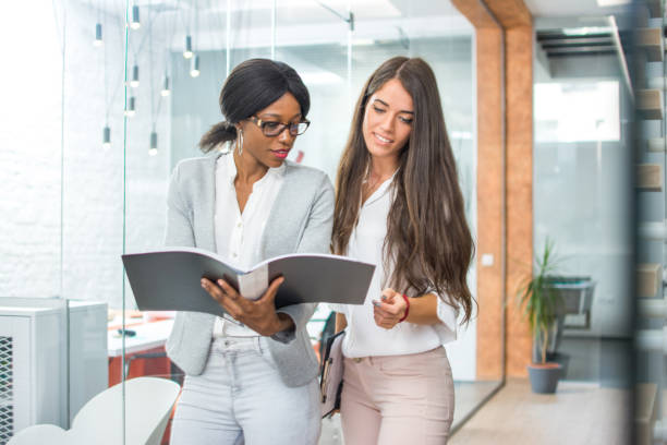 istock Two business women discussing business documents in modern office. 936236888