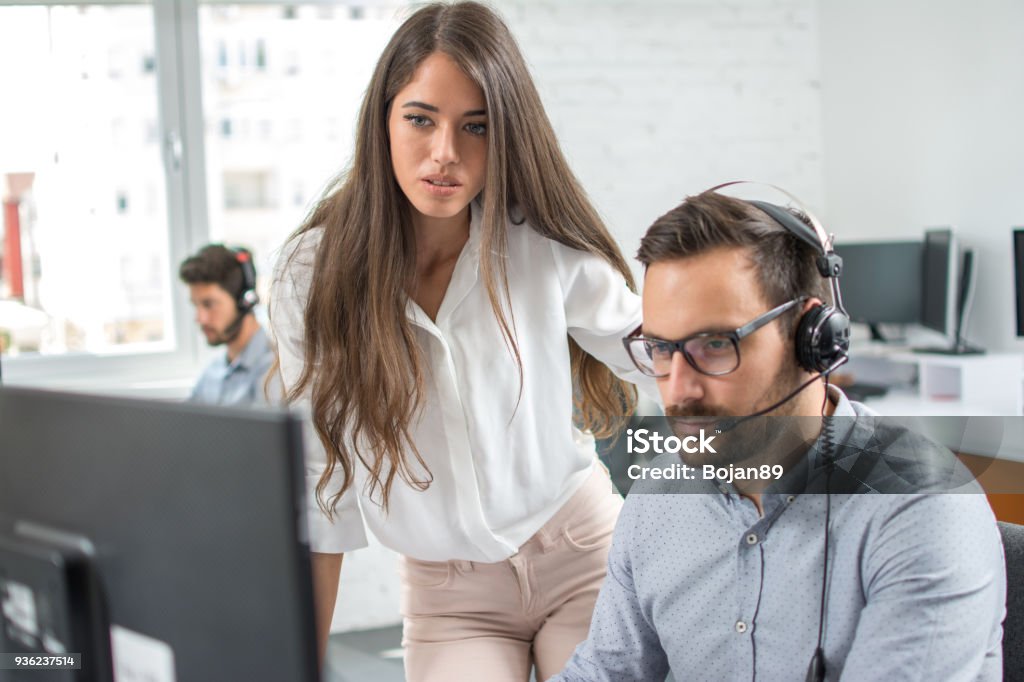 Customer support workers solving problems together on client's online account in call centre office. Customer Service Representative Stock Photo