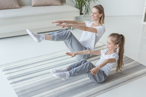 madre e hija haciendo v-sit cruje en la estera de la yoga photo