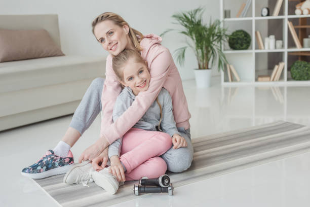 istock mother and daughter relaxing on yoga mat after training 936240708