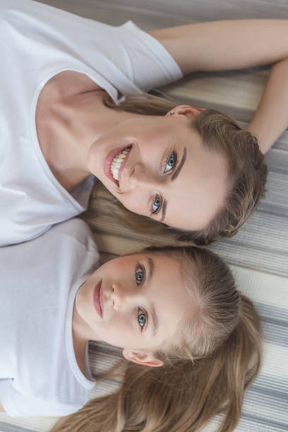 istock top view of mother and daughter looking at camera while relaxing 936252274