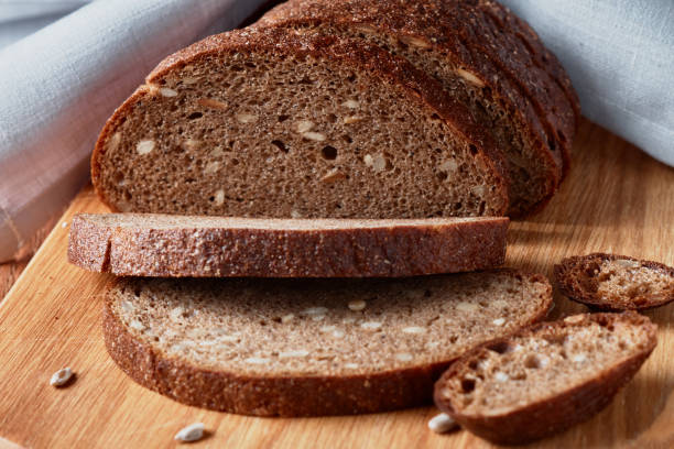 istock Slice of rye bread with seeds on a wooden background 936258364