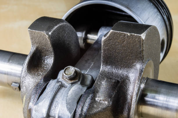 istock Crankshaft, piston and other parts of the internal combustion engine. Disassembled single-piston four-stroke engine on the workbench. Black background. 936258466
