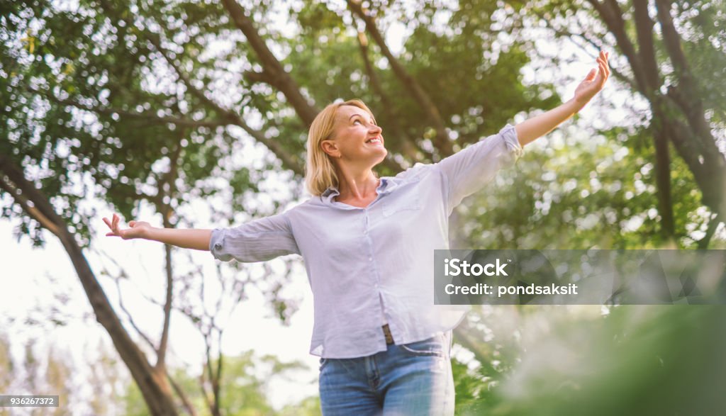 happy woman open arms with freedom relax happy woman in spring or summer forest park open arms with happiness, hope and vitality. Caucasian girl relaxing and enjoying life on nature outdoors. Women Stock Photo