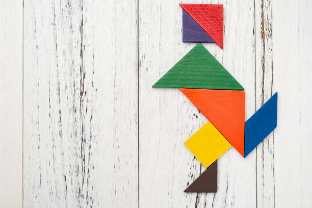 istock wooden tangram shaped like a people skating on white with copy space 936267420