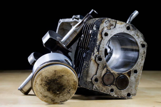istock Crankshaft, piston and other parts of the internal combustion engine. Disassembled single-piston four-stroke engine on the workbench. Black background. 936268032
