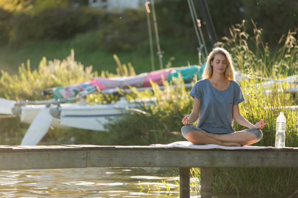 istock woman meditating on pontoon 936273014