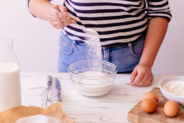 istock Woman is going to bake, mixing flour in a bowl 936276168