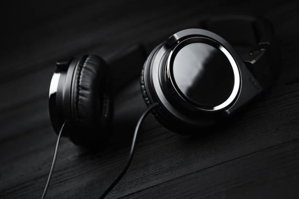 istock Black headphones on black wooden dark background. 936276944