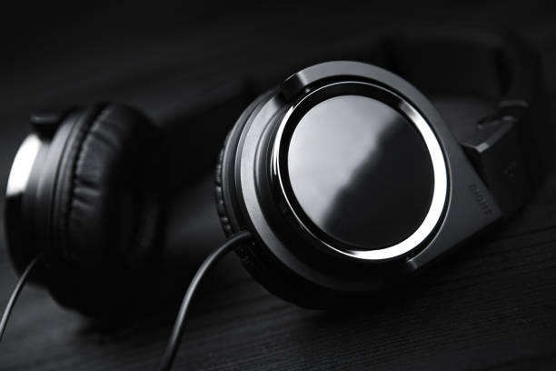 istock Black headphones on black wooden dark background. 936277314