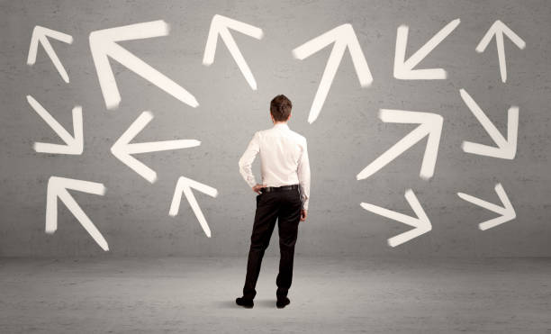 istock Confused salesman with arrows on wall 936278654
