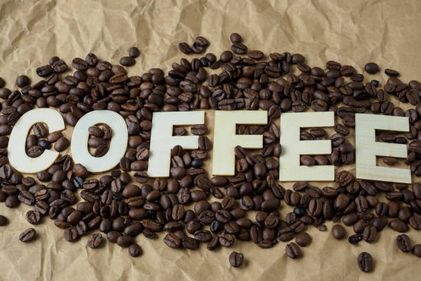 istock Roasted coffee beans on brown wrapping paper. The word 