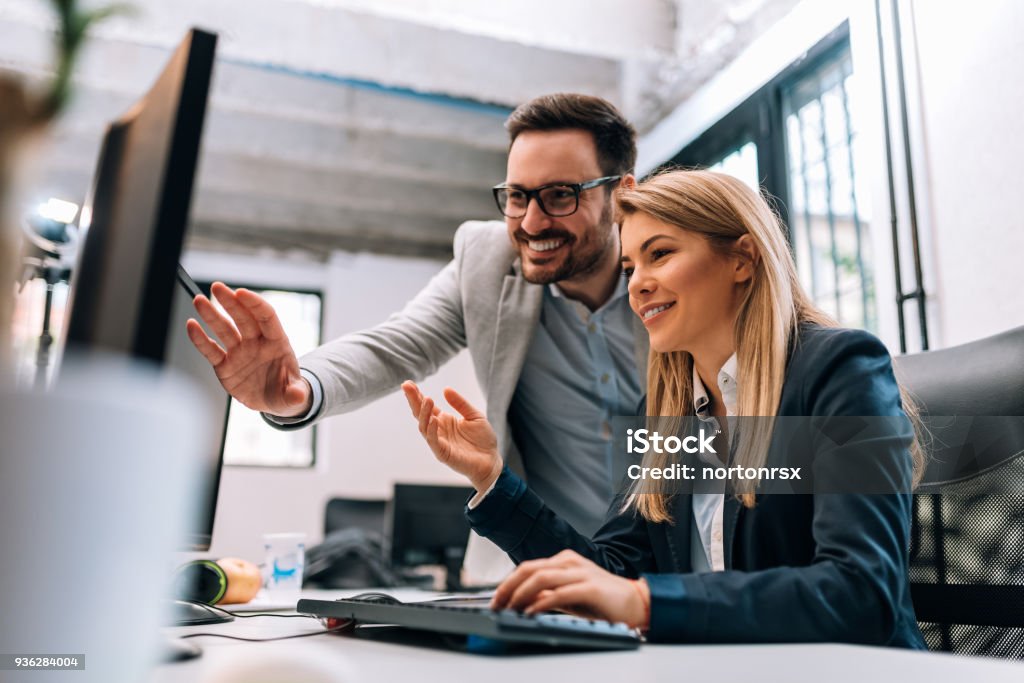 Working together on project. Two young business colleagues working on computer Office Stock Photo