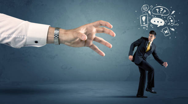 istock Business man running from a big hand 936284662