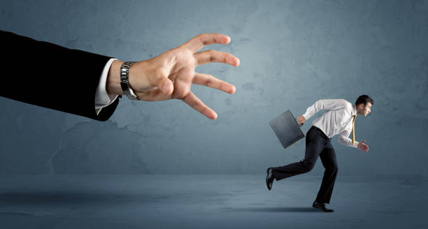 istock Business man running away from a huge hand concept 936284768