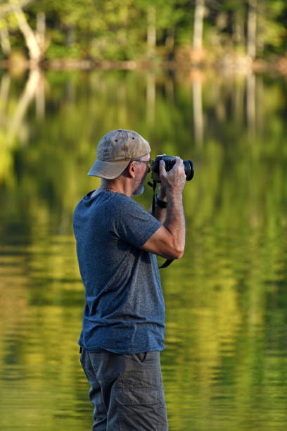 istock Senior Man Taking Pictures at Lake 936287088