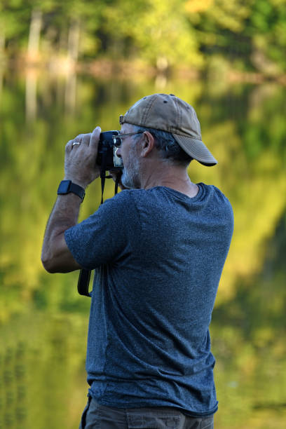 istock Senior Man Taking Pictures at Lake 936287174