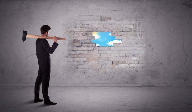 istock Business man hitting brick wall with hammer 936287450