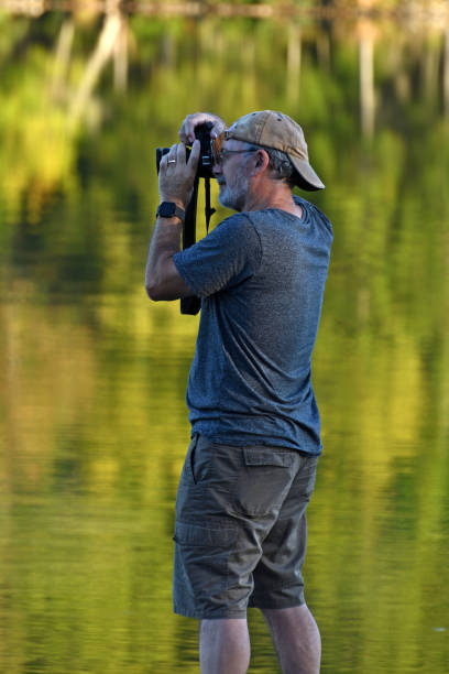 istock Senior Man Taking Pictures at Lake 936288096
