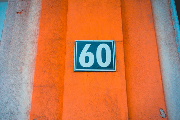 istock blue number 60 door sign on orange wall 936290858