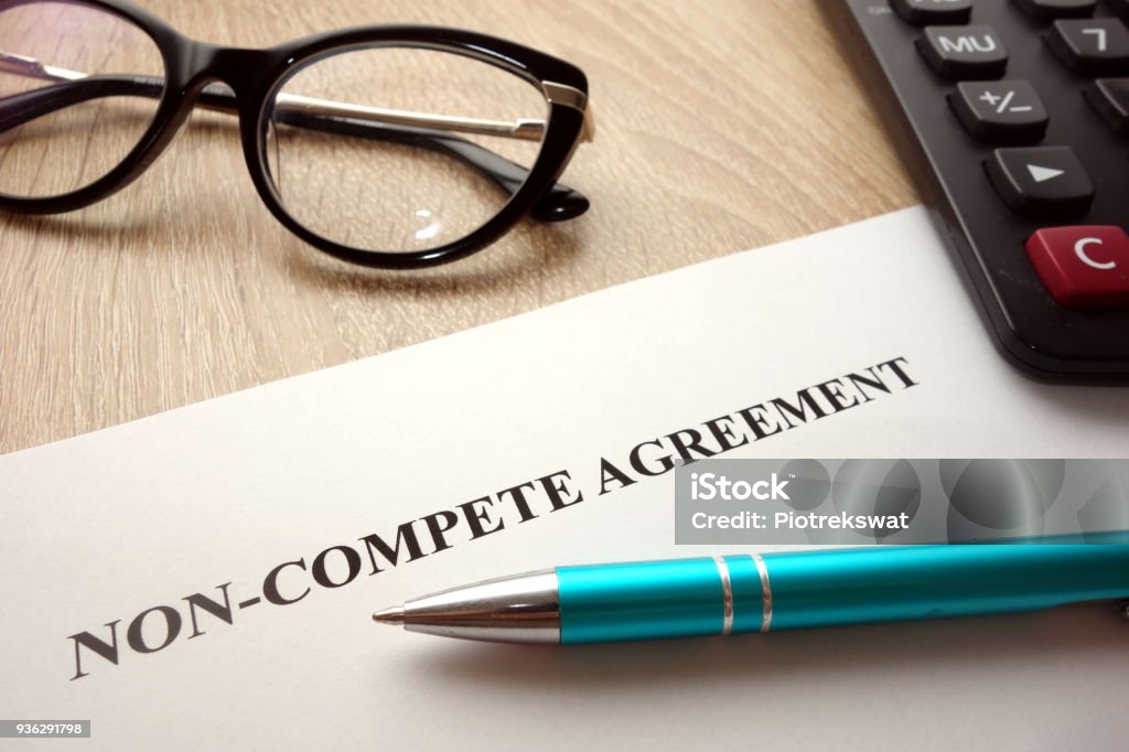 Non-compete agreement Non-compete agreement document for filling and signing on desk, 
business competition concept Contract Stock Photo