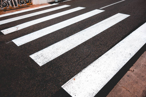 istock some pedestrians lines on a black road 936294702
