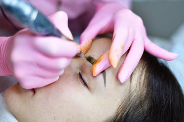 istock The master makes eyebrow tattoos for young girl 936297352