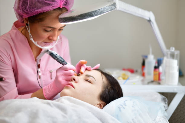 istock The master makes eyebrow tattoos for young girl 936297494
